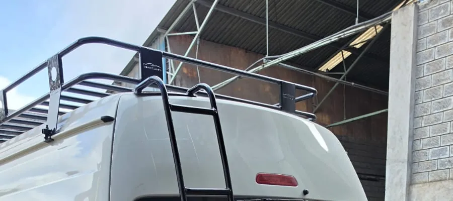 Roof rack and rear ladder on a white high-roof Toyota Hiace at the workshop