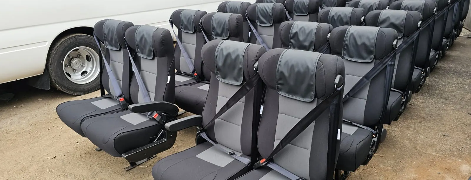 Grey and black executive seats with seat belts in the workshop yard