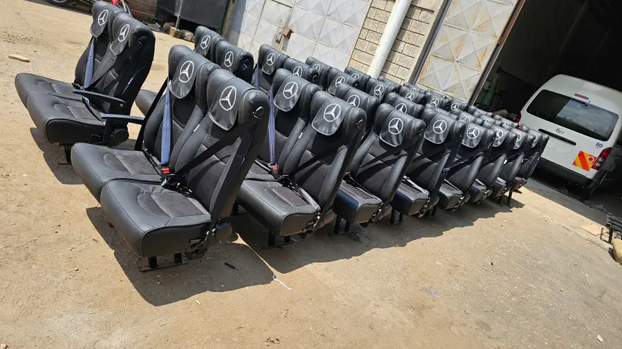 Rows of bus seats with the Mercedes-Benz star on each headrest