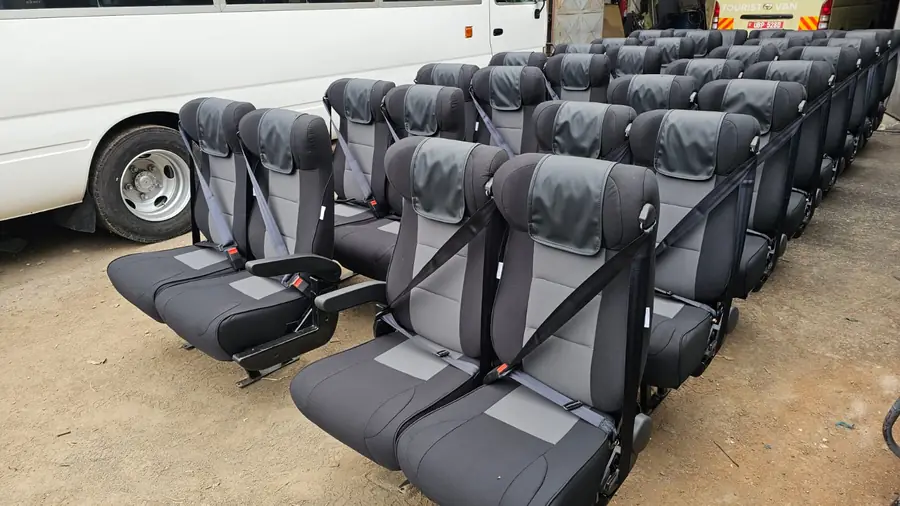 Grey and black executive seats with seat belts in the workshop yard