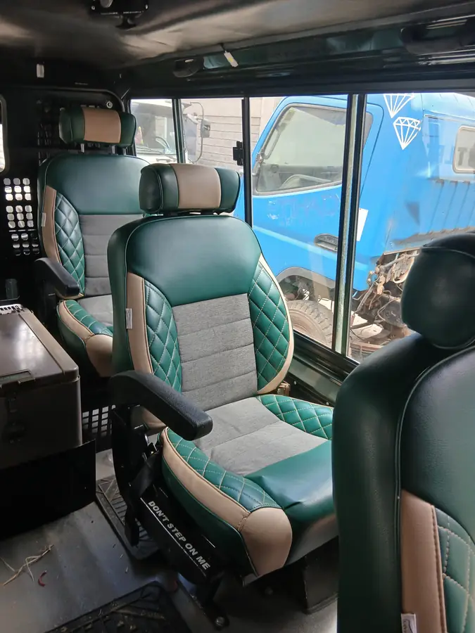 Green and grey diamond-stitch Land Cruiser seats fitted in a vehicle cabin