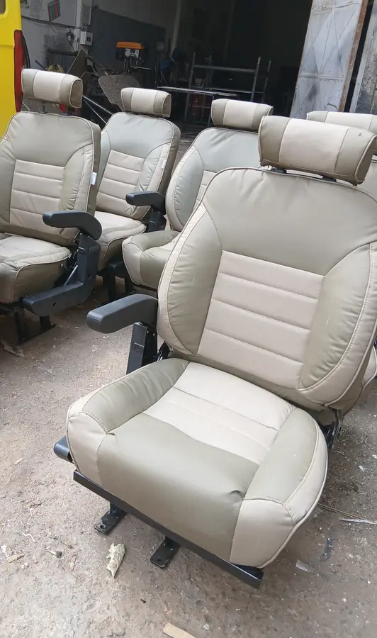 Beige two-tone Land Cruiser seats with armrests in the workshop
