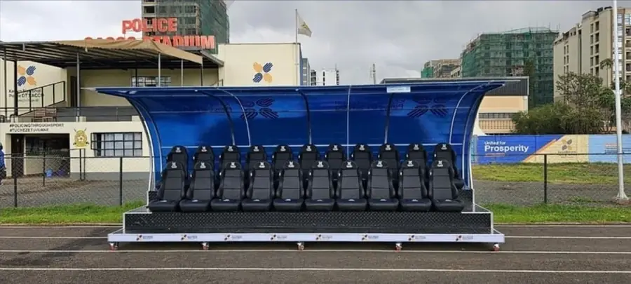 Team dugout with rows of black bucket seats at a stadium