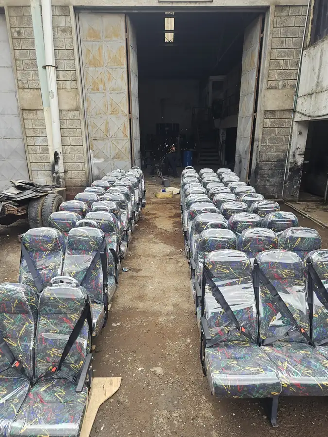 Rows of standard seats with seat belts, wrapped and ready in the workshop yard