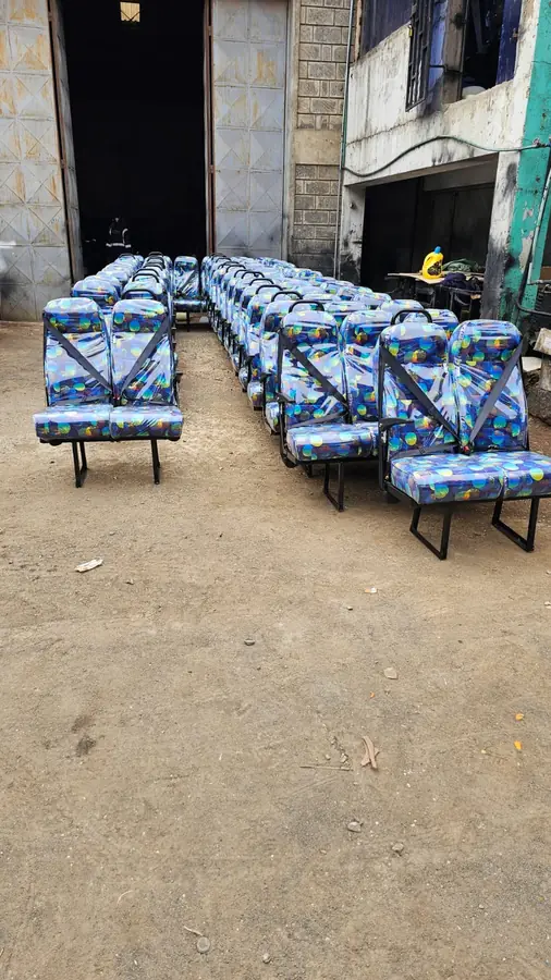 Rows of patterned standard seats with seat belts outside the workshop