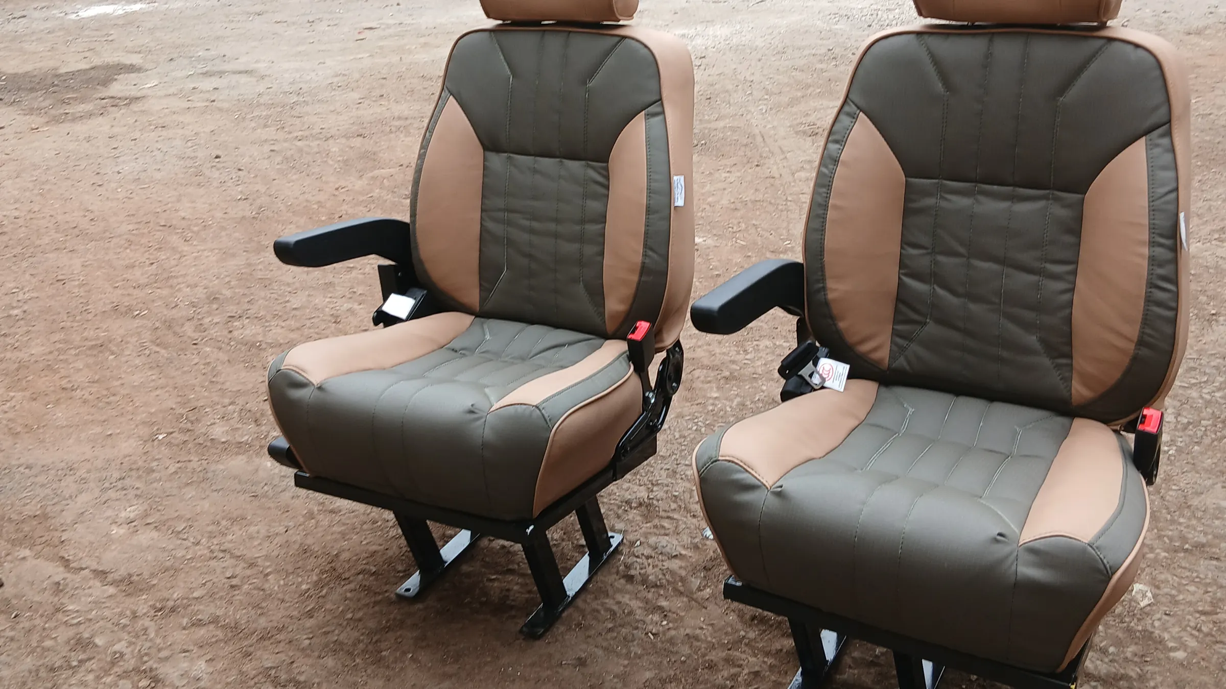 A pair of tan and olive Land Cruiser captain seats in the workshop yard