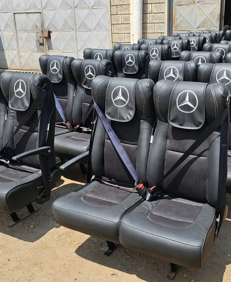 Rows of bus seats with seat belts in the workshop yard