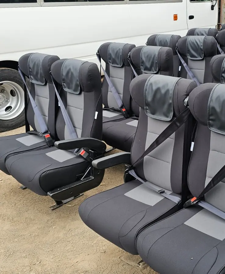 Grey and black executive seats with seat belts in the workshop yard