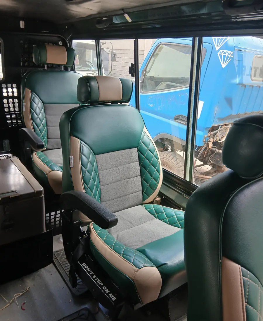 Green and grey diamond-stitch Land Cruiser seats fitted in a cabin