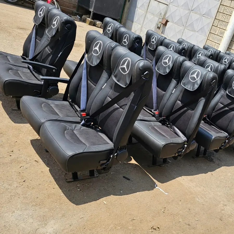 Rows of bus seats with the Mercedes-Benz star on each headrest in the workshop yard