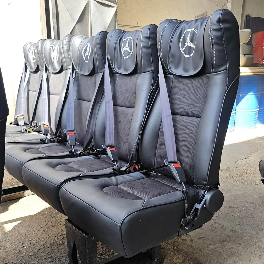 Close-up of a row of bus seats with Mercedes-Benz headrests and seat belts